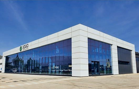 Lo stabilimento SOGO visto dall'esterno: edificio a due piani con facciata vetrata e insegna