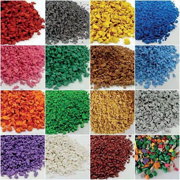 Sedici campioni di granulato colorato affiancati: rosso, giallo, blu, verde, arancio, grigio, bianco e altre tinte
