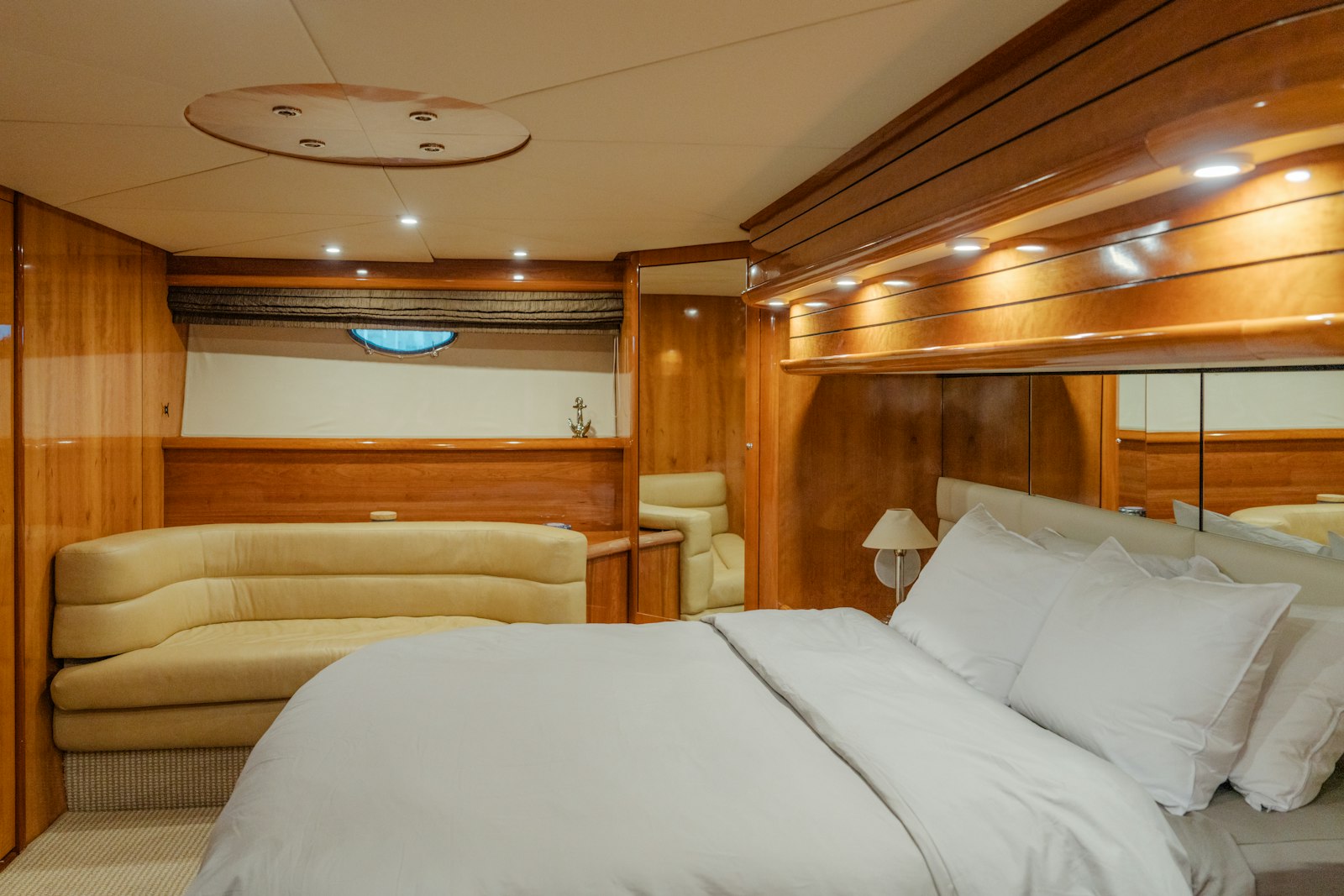 Cabina di uno yacht con le pareti rivestite in legno e il letto matrimoniale