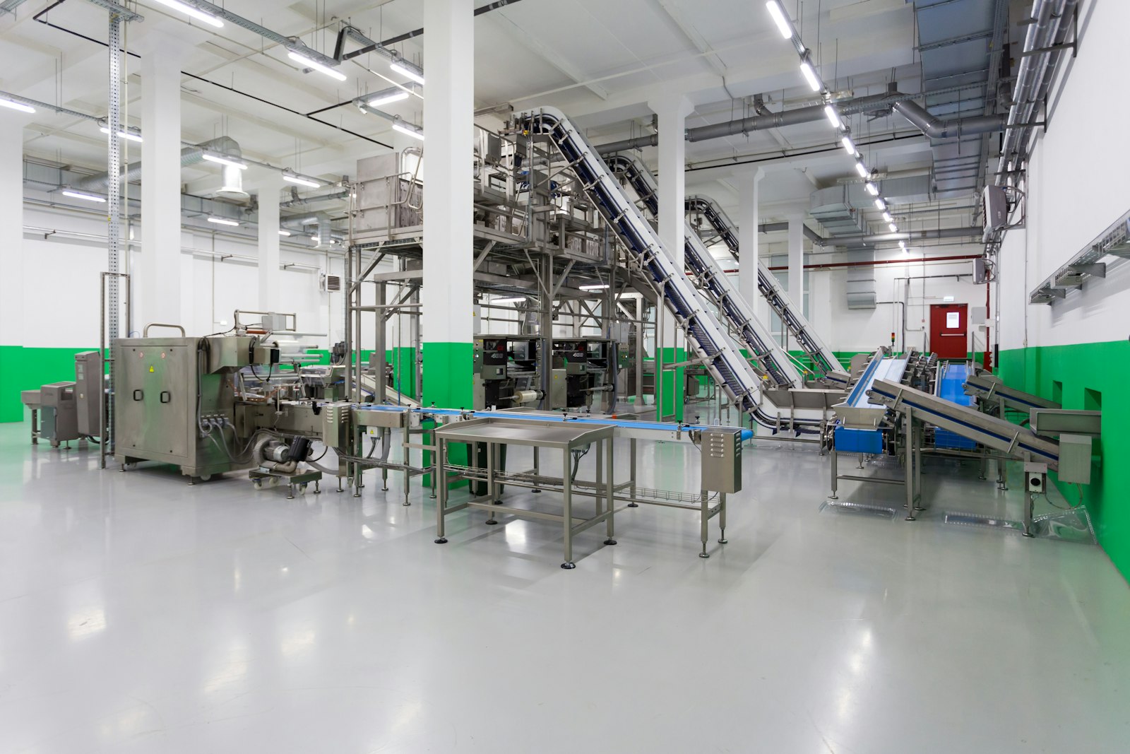 Linea di produzione con nastri trasportatori su un pavimento in resina chiaro